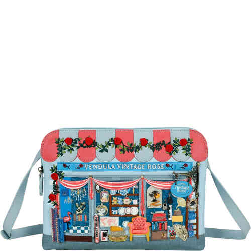 This is an east west crossbody bag, medium in size, that will fit an iPad in its case easily. , It is made from soft pale blue vegan leather, adorned with embroidered roses, and 3D elements of a vintage phone, a book case with books, and artwork on the wall. Vegan bag/accessory designed by Vendula London, available online and instore at ShoeBeDoo, official stockist in Australia